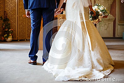 The bride and groom hold hands in front of the altar Stock Photo