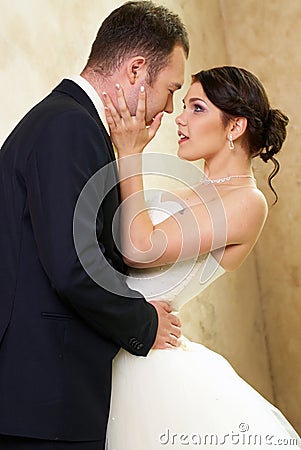 Bride and groom hugging in empty room Stock Photo