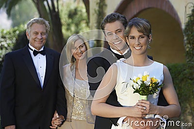 Bride And Groom With Parents In Background Stock Photo