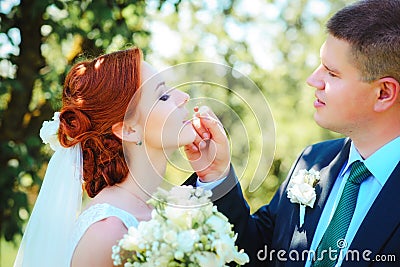 The bride and groom in the Park.man feeds his beloved strawberri Stock Photo