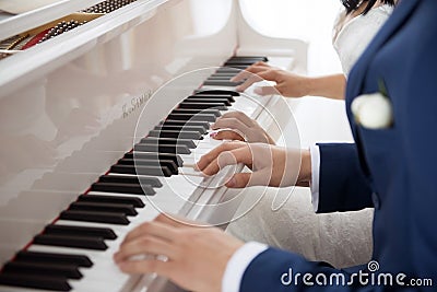 The bride and groom play the piano in two hands Stock Photo