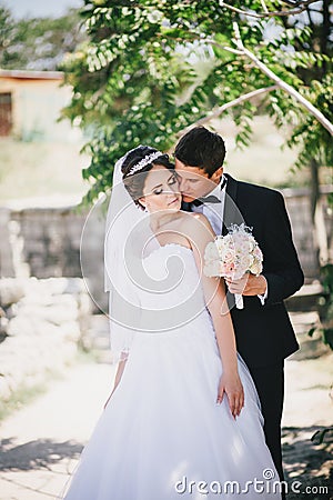 Bride and groom posing on the background of ancient ruins Stock Photo