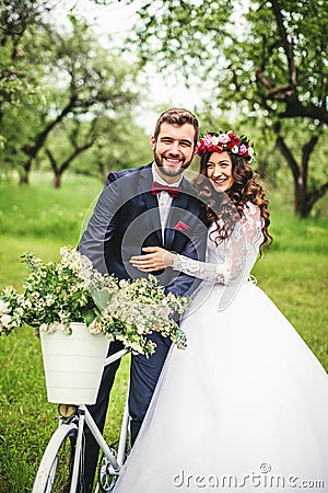 Bride & groom posing near bicycle Stock Photo