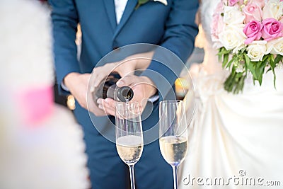 Bride and groom pouring champagne at a wedding ceremony. Stock Photo