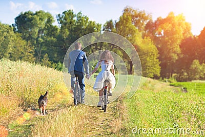 Bride and groom ride bicycles Stock Photo