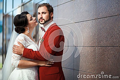 Bride and groom, romantic wedding couple in a passionate outburst, near walls of building. Stock Photo