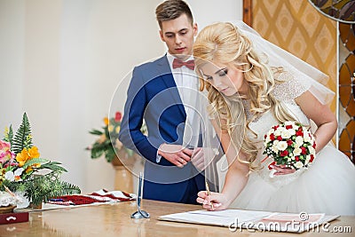 Bride and groom signing marriage wedding certificate Stock Photo