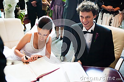 Bride and groom signing registry Stock Photo