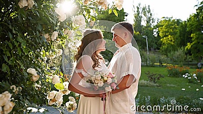 Bride And Groom Are Smiling And Kissing Near Lush White Roses Bush