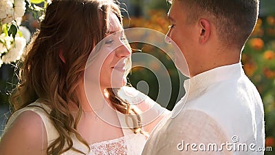 Bride And Groom Are Smiling And Kissing Near Lush White Roses Bush