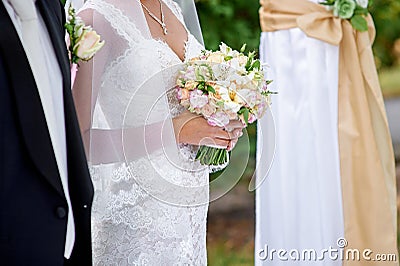 Bride and groom stand under the arch at the wedding ceremony Stock Photo