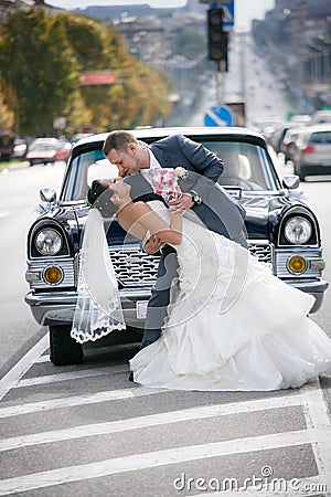 Bride and groom on the street near the car Stock Photo