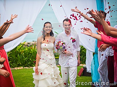 The bride and groom after the wedding ceremony. Guests showered the newlyweds with rose petals Stock Photo