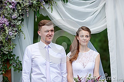 Bride and groom at a wedding ceremony under the arch Stock Photo