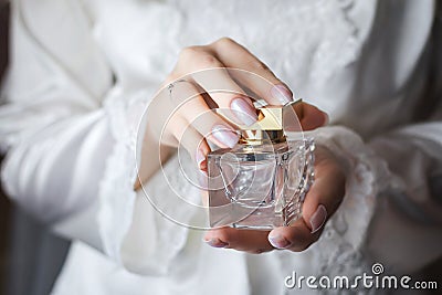 Bride holding in hands a flacon of luxury perfume Stock Photo