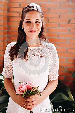 Bride holding her small wedding bouquet of pink roses. Wedding day concept Stock Photo