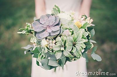 Bride holding the wedding bouquet, with succulent flowers, Stock Photo