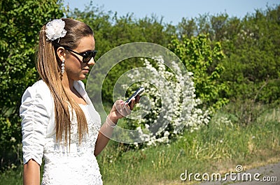 Bride makes call on mobile phone Stock Photo