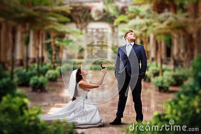 Bride makes an offer in green garden Stock Photo