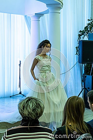 A bride model in a wedding dress walking down from a podium Editorial Stock Photo