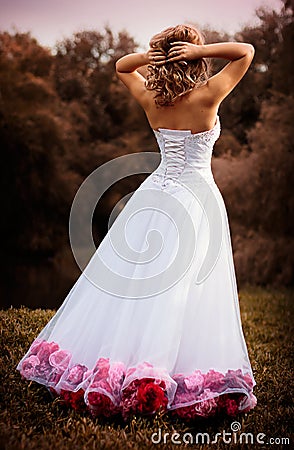 Bride portrait in white bridal veiling with artificial bunch photo session, leaves and trees background, snow weather art, fashion Stock Photo