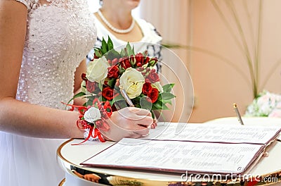 Bride puts signature in registry office. Stock Photo