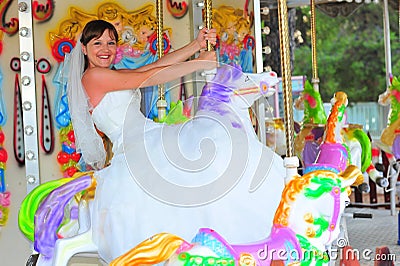 Bride riding the carousel Stock Photo