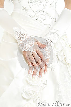 Bride's hands with manicure in white lace gloves Stock Photo