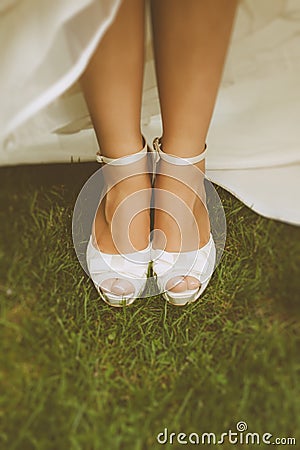 Bride's White Shoes on a Grass Floor Stock Photo