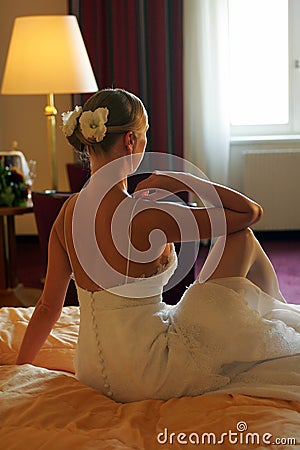 Bride sat on bed rear view Stock Photo