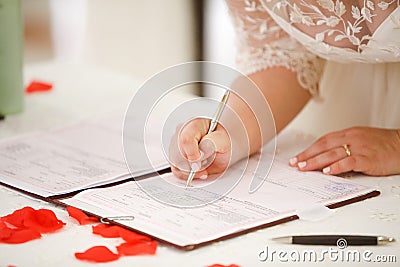 Bride signs marriage certificate Stock Photo