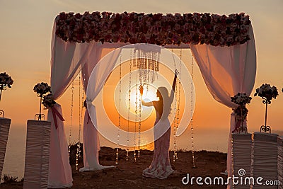 Bride silhouette. Wedding ceremony arch with flower arrangement Stock Photo