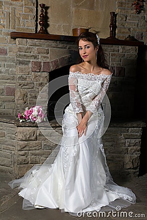 Bride sitting in front of fireplace Stock Photo