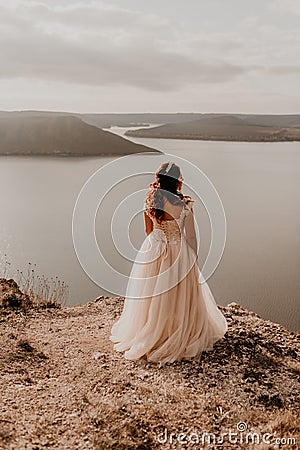 bride stands on a cliff against the background of the river and islands Stock Photo