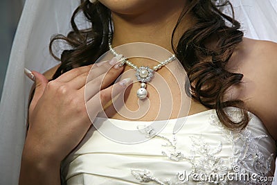 Bride straightens his jewelry on the neck Stock Photo
