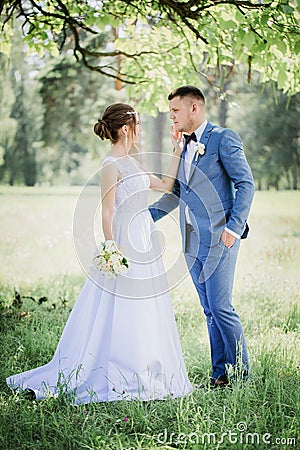 The bride strokes the groom`s face Stock Photo