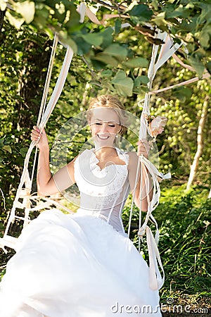 Bride on a swing. Joy, happiness, cheerful. Wedding day Stock Photo