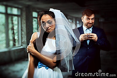 Bride with tearful face and groom with sly smile Stock Photo