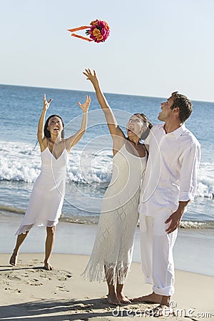 Bride Throwing Bouquet On Beach Stock Photo