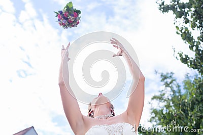 Bride throwing flower bouquet at wedding Stock Photo