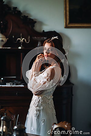 A bride in underwear and a white robe in the interior of a Villa in Italy at a wedding.morning of the bride in Tuscany.boudoir Stock Photo