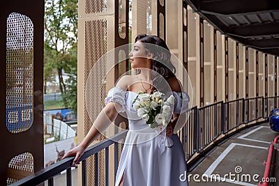 The bride waits with bated breath for the groom. Sexy bride in the parking lot. Stock Photo