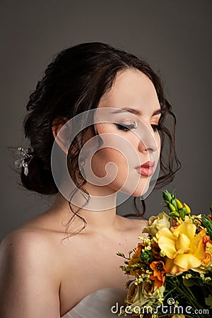 Bride in white dress with bouquet in photostudio Stock Photo