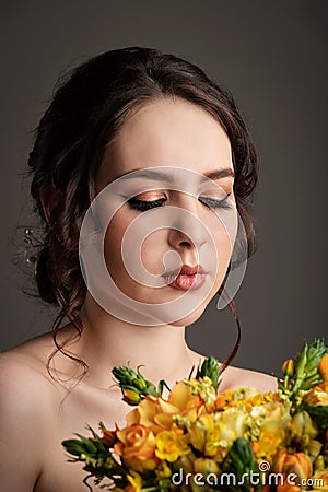 Bride in white dress with bouquet in photostudio Stock Photo