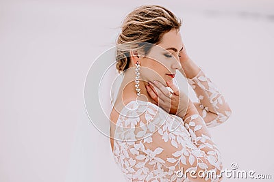 Portrait of a beautiful bride in the desert, blonde posing for a photographer on a wedding day Stock Photo