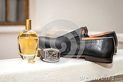 Bridegroom`s wedding ring, perfume, watch and black leather shoe Stock Photo