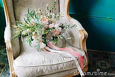 Brides wedding shoes with a bouquet with roses and other flowers on tha arm chair Stock Photo