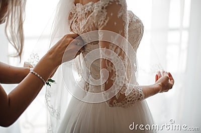 Bridesmaid making bow-knot on the back of brides wedding dress Stock Photo