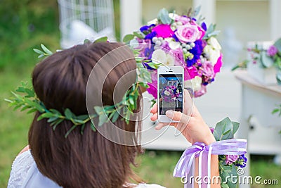 Bridesmaid photographing a wedding bouquet on the phone. Florist Stock Photo