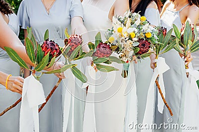 Bridesmaids in blue dresses and bride holding beautiful bouquets of protea flowers. Beautiful luxury wedding blog concept. Stock Photo